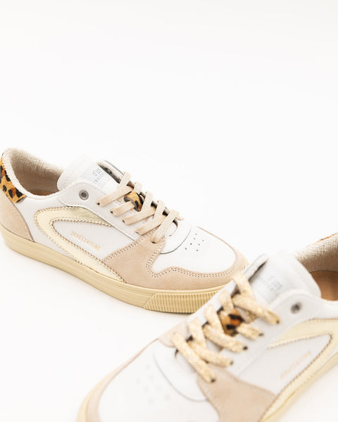 The 0-105 Julia with the iconic boomerang, this time in gold, matching the laces that contrast nicely with the touch of leopard on the back. A detail that's sure to spice up even the simplest of looks.