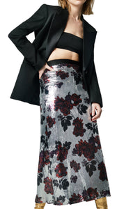 A model wearing a Smythe silver sequin floral skirt with a black top and gold platform heels.