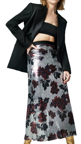 A model wearing a Smythe silver sequin floral skirt with a black top and gold platform heels.