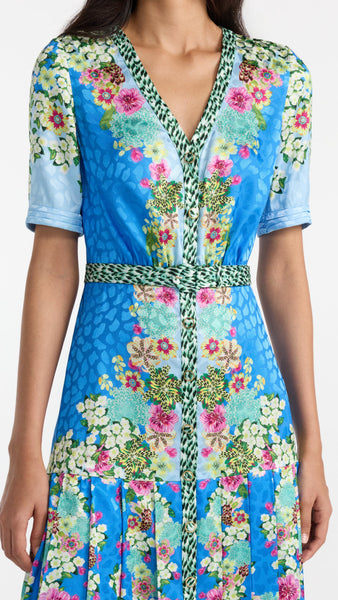 Woman wearing a colorful floral dress with a blue background