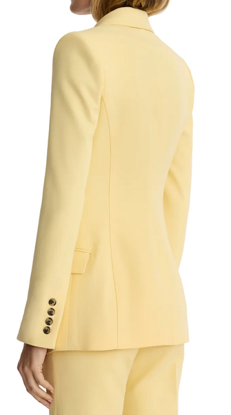 Woman wearing a yellow suit against a white background