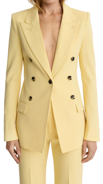 Woman wearing a light yellow suit with a white background