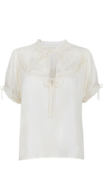 White blouse with lace details on a white background