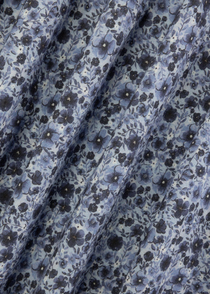 Close-up of floral fabric with blue and black flowers on a light background
