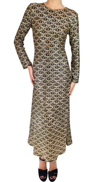A long-sleeve maxi dress with an all-over repeating black and beige monogram pattern, modeled against a plain white background.