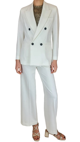 Person wearing a white suit with black buttons on a plain background