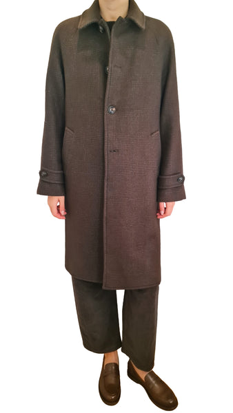 A person wearing a long brown coat with a subtle houndstooth pattern, matching brown trousers, and brown leather loafers
* Circolo wool coat
* Circolo 1901 brown wool plaid coat
* Women's single-breasted brown wool coat
* Circolo 1901 raglan sleeve wool coat
* Brown Glen check wool outerwear women
* Luxury Italian brown wool coat
* Tailored knee-length brown plaid coat
* Designer brown micro check wool coat