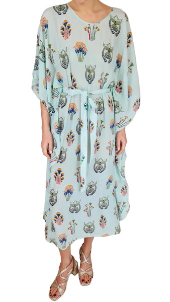 Person wearing a light blue dress with floral and animal print on a white background