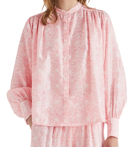 Woman wearing a pink outfit with a plain background