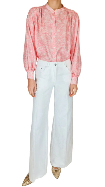 Person wearing a pink blouse and white pants on a plain background