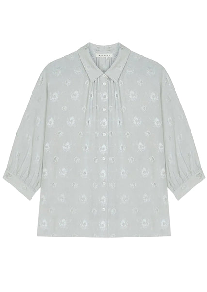 Light gray blouse with subtle pattern on a white background