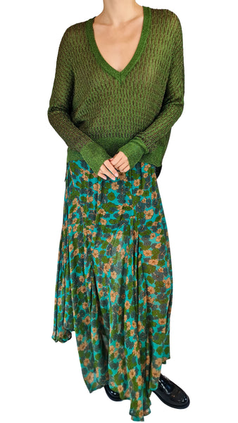 Add luminous texture to your winter knitwear collection with the Mes Demoiselles Glee Green Metallic V-Neck Sweater, an effortless slouchy knit woven with shimmering metallic lurex threads.   
Rendered in a vibrant mossy olive green, this relaxed jumper features a flattering deep V-neckline, drop shoulders, and fine ribbed trims at the neck, cuffs, and hem. Designed with an airy, open-work knit pattern, it offers an ideal sheer layer for high-low winter styling. Pair it over floral chiffon maxi dresses,