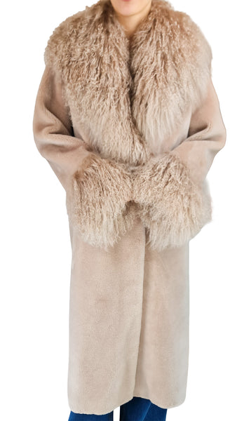 A long beige faux-shearling coat with a large shaggy beige fur collar and matching faux-fur cuffs, shown on a model against a white background.