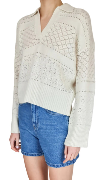 White textured sweater worn with blue denim shorts on a plain background