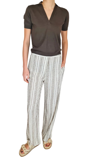 Person wearing a brown top and striped pants on a plain background