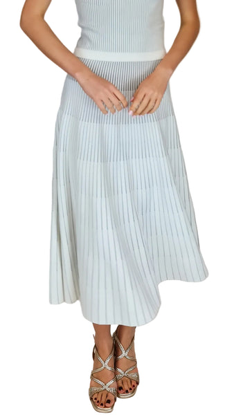 Person wearing a light blue pleated skirt with a plain background