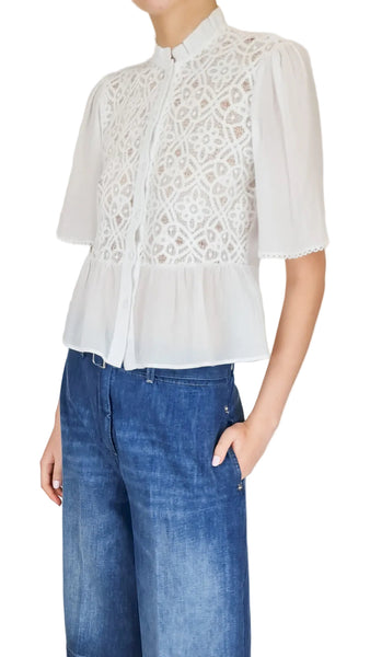 White lace blouse with blue jeans on a plain background