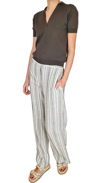 Person wearing a brown shirt and striped pants on a plain background