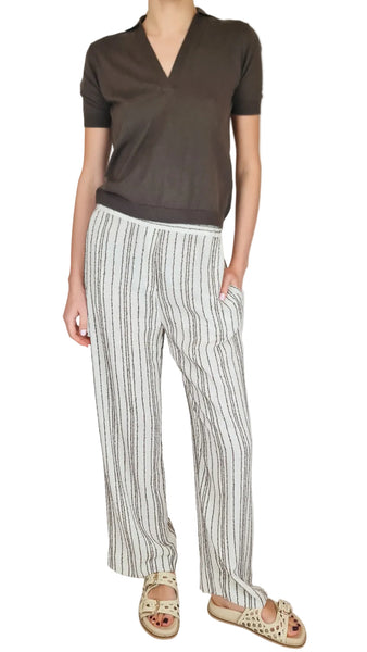Person wearing a brown top and striped pants on a plain background