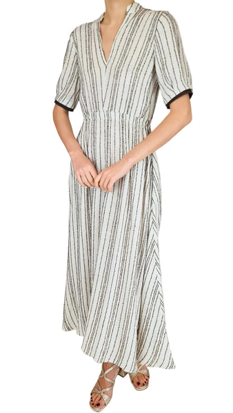 Person wearing a long, striped dress with a plain background