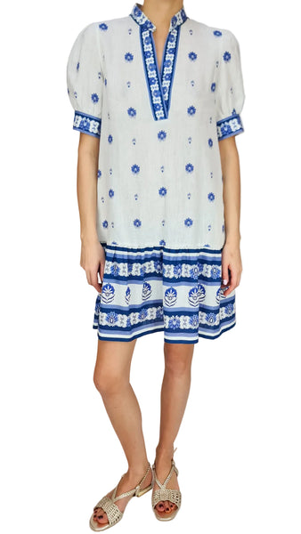 White dress with blue floral patterns on a plain background