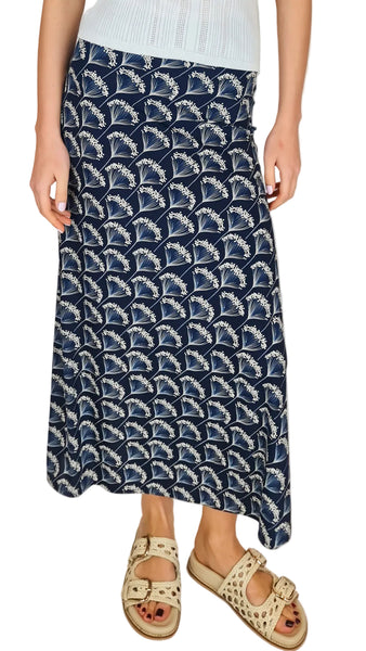 Person wearing a navy blue patterned skirt on a plain background