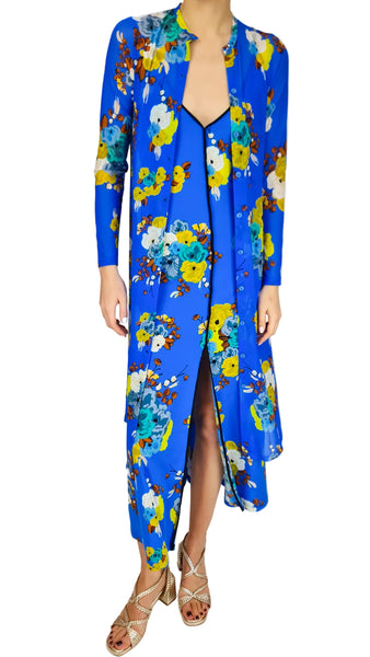 Woman wearing a blue floral dress with a slit on a white background
