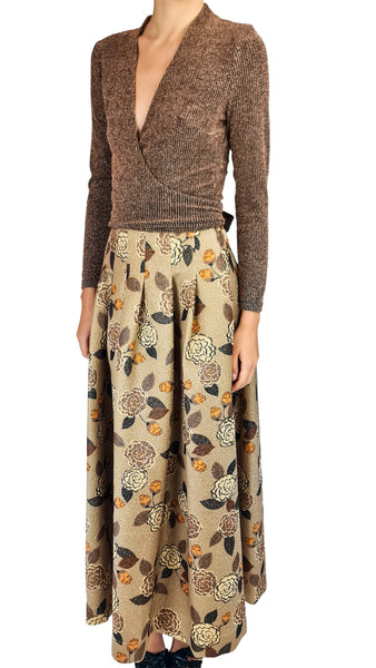A model wearing a brown knit wrap cardigan and a beige maxi skirt with a brown and orange floral pattern, shown against a plain white background.