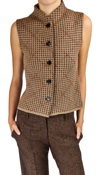 A sleeveless brown and beige houndstooth vest with black buttons, worn by a model with brown trousers against a white background.