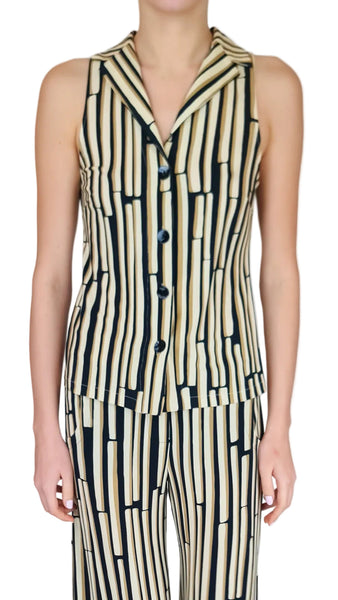 Person wearing a sleeveless, vertically striped dress with black and beige pattern on a plain background