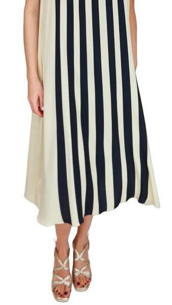 Woman wearing a dress with black and white vertical stripes on a plain background