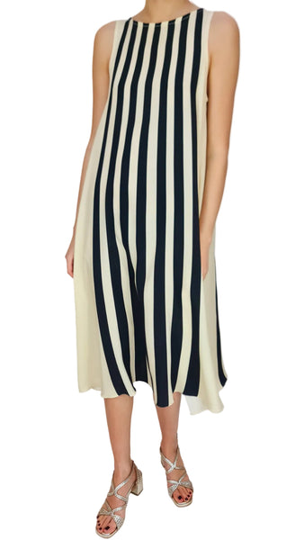 Person wearing a black and white striped dress on a plain background