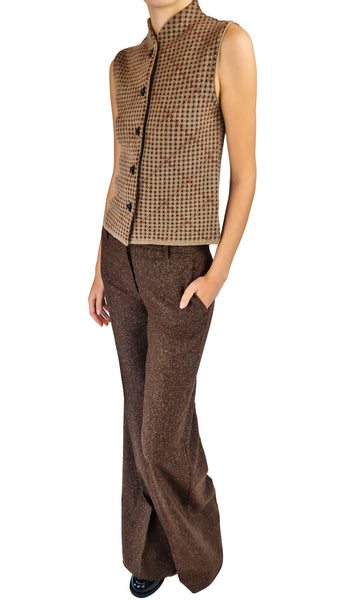 A model wearing a brown and beige houndstooth sleeveless vest paired with matching brown textured wide-leg trousers, shown against a plain white background.