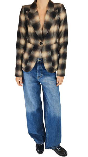 A model wearing a brown and beige plaid blazer with wide-leg blue jeans and black shoes, shown from the neck down against a plain white background.