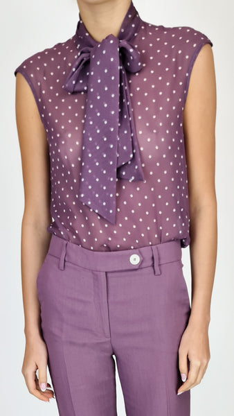 This sheer purple t-shirt features a playful polka dot design and a chic bow detail at the neckline. Perfect for adding a touch of fun to any outfit. Upgrade your wardrobe today!