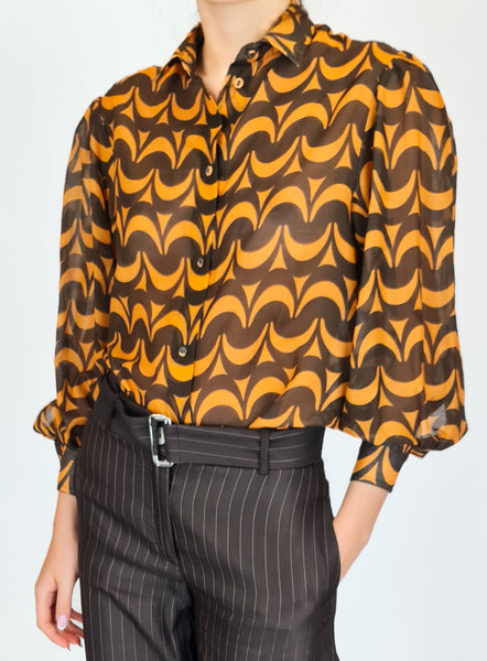Experience a modern take on retro with this True Royal blouse. Made with sheer silky material, this top features a sweet print in rich brown and soft orange, and adds dimension with voluminous sleeves.