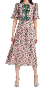 This gorgeous Saloni statement dress in pink and green star print features short bell sleeves, a keyhole opening front, and a trio of statement-making embroidered bows up the center front. Crafted in a silk georgette to the ankle length, pair it with minimal accessories and heels.